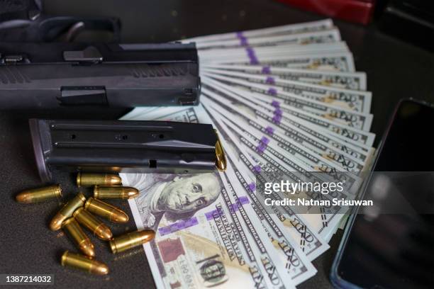 black gun on american dollars background. - trafficking stockfoto's en -beelden