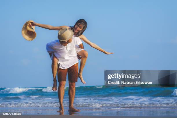 happy relaxing couple in love on beach summer vacations. - southeast asian ethnicity stock pictures, royalty-free photos & images