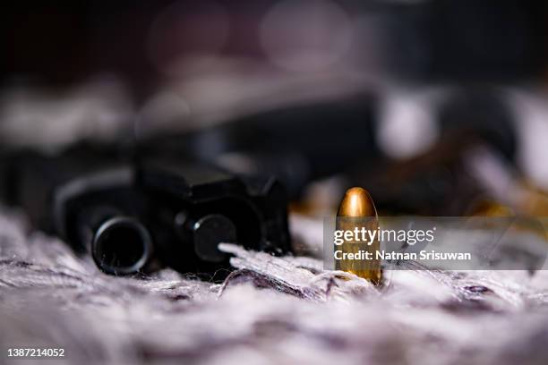photo of a gun and bullets on floor. - tiroteio imagens e fotografias de stock