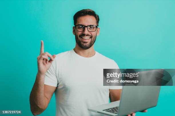 young man wearing eyeglasses using a laptop - laptop colored background stock pictures, royalty-free photos & images