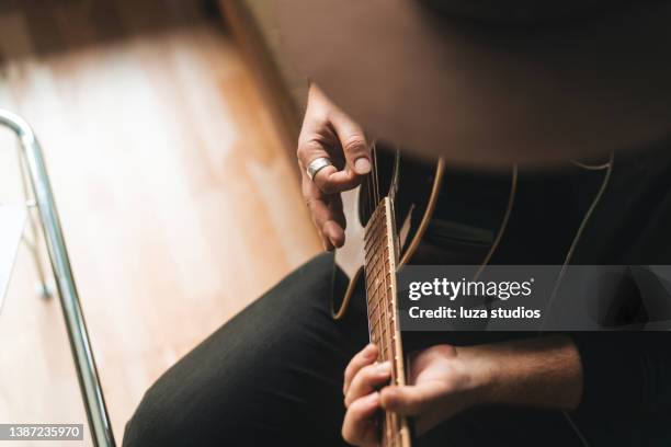 un musicista che suona la sua chitarra a casa - acoustic guitar foto e immagini stock