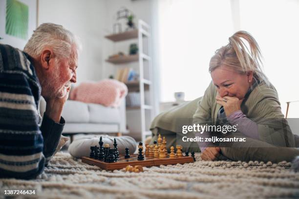 senior friends at home playing board games - playing board games stock pictures, royalty-free photos & images