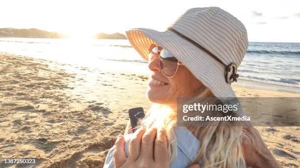 pov of woman relaxing on sandy beach, in the sun - a woman wear hat and sunglasses stock pictures, royalty-free photos & images
