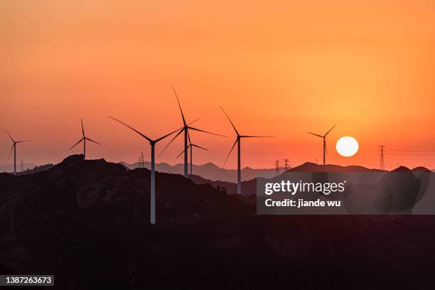 the wind turbine on the top of the mountain, at sunset - low carbon technology stockfoto's en -beelden