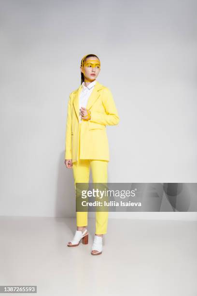 female model in yellow suit - gelber anzug stock-fotos und bilder