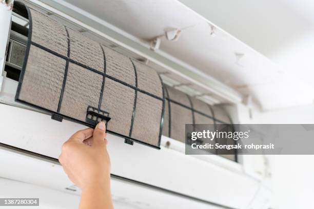 cleaning the air conditioner filter - cu fan - fotografias e filmes do acervo