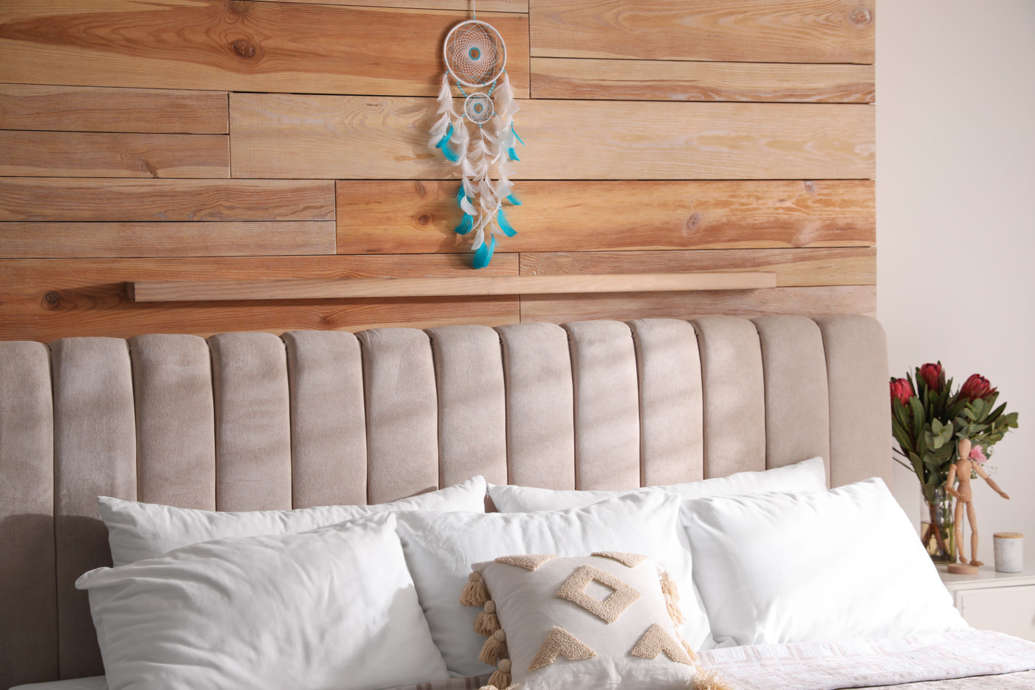 Beautiful dream catcher hanging above bed in stylish room interior Beautiful dream catcher hanging above bed in stylish room interior
