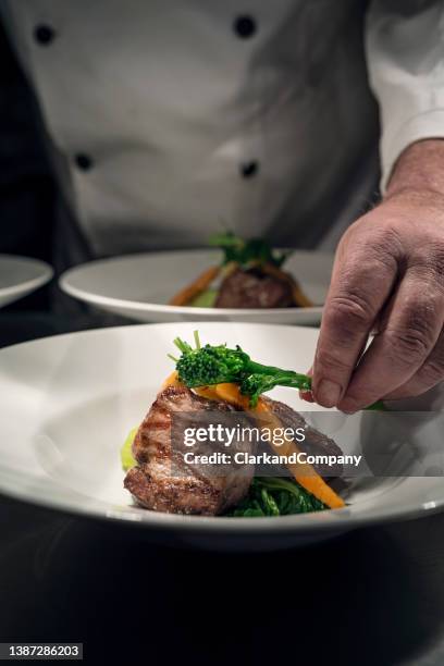 chefkoch bereitet essen am pass zu - medallion stock-fotos und bilder