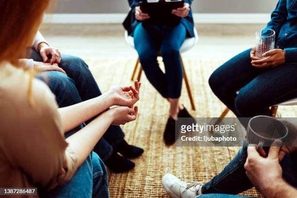 mental health patient talking to the group at therapy. - adult woman cup tea stock pictures, royalty-free photos & images