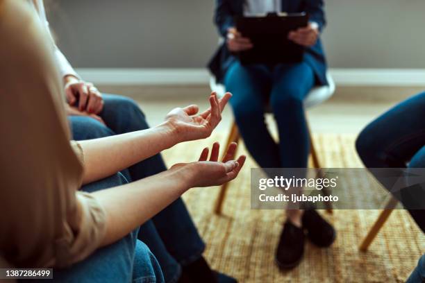 people attending support group meeting for mental health or dependency issues in community space - therapist imagens e fotografias de stock