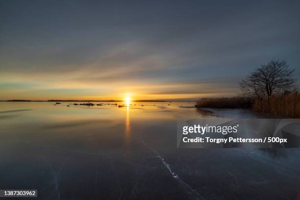 sunset reflections,scenic view of frozen lake against sky during sunset,arboga,sweden - arboga stock pictures, royalty-free photos & images