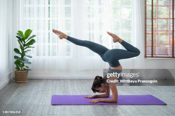young flexible woman doing sports exercises on exercise mat in the class - upright position stock pictures, royalty-free photos & images