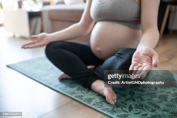 unrecognisable pregnant woman practicing mindfulness meditation techniques. - fase da reprodução humana imagens e fotografias de stock