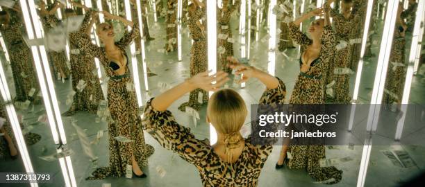 donna in una stanza a specchio infinito. piovono soldi - infinità foto e immagini stock