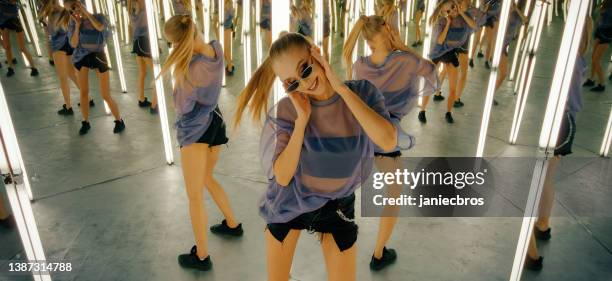 mujer en una habitación de espejo infinito. bailar y divertirse - infinite mirrors fotografías e imágenes de stock