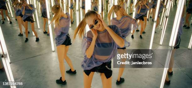 woman in an infinity mirror room. dancing and enjoying herself - always on stockfoto's en -beelden