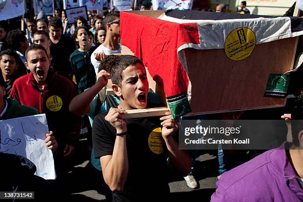 Students carry a symbolic coffin in rememberance for student who was killed in Port Said during the recent football match clashes on February 11,...