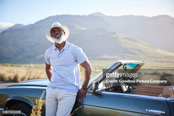 smiling mature man enjoying the view during a break from a scenic drive - convertible car stock pictures, royalty-free photos & images