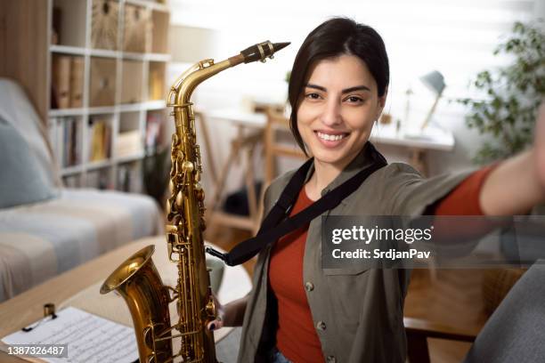 proud young caucasian female saxophonist taking selfie - saxophone player stock pictures, royalty-free photos & images