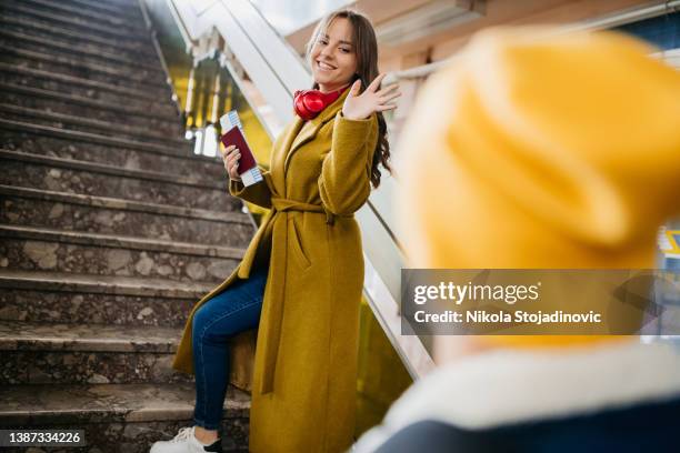 junges paar winkt am bahnhof - waving hands goodbye stock-fotos und bilder