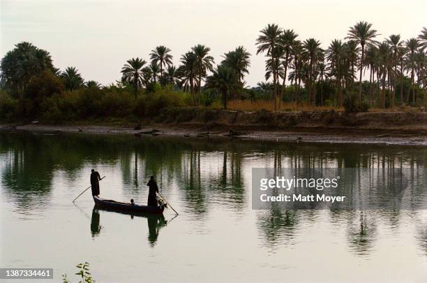 Fisherman casts a net on the Euphrates river on November 21, 2003 near Kufa, Iraq.