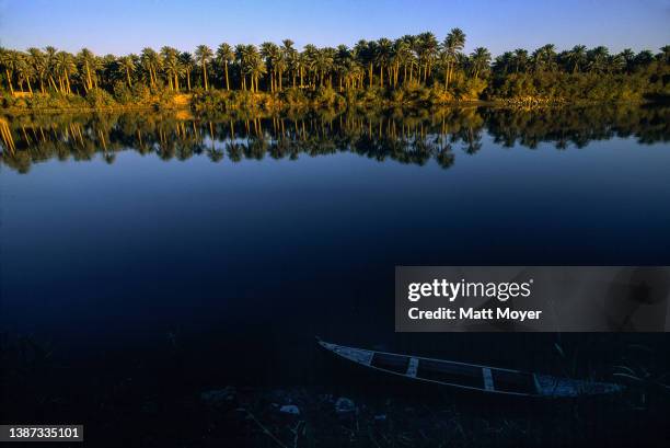 Trees reflect in the Euphrates River on November 22, 2003 in Kufa, Iraq.