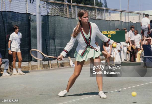 American tennis player Chris Evert, wearing a white cardigan over a pale green tennis dress, preparing for her final against Evonne Goolagong at the...