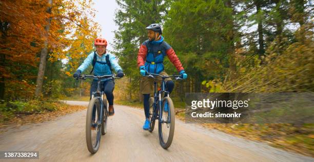 junge freunde mountainbiken im herbstwald - bicycle trail outdoor sports stock-fotos und bilder