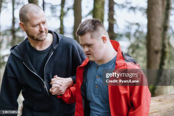 caretaker hiking with adult disabled man - intellectually disabled stockfoto's en -beelden