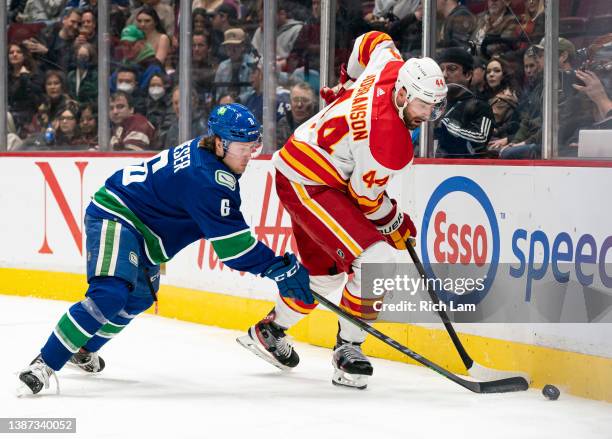 Brock Boeser of the Vancouver Canucks tries to check Erik Gudbranson of the Calgary Flames off the puck during NHL action on March 2022 at Rogers...