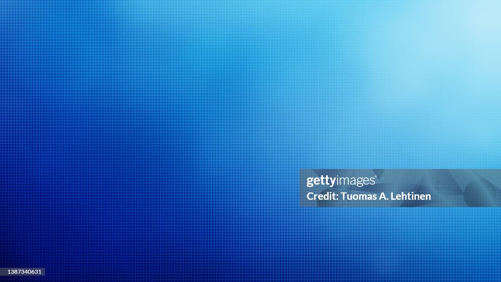 Abstract blue halftone pattern on blurred blue color gradient background.