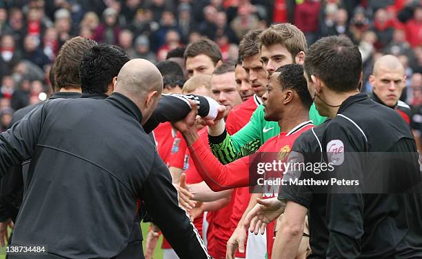 Luis Suarez of Liverpool refuses to shake the hand of Patrice Evra of Manchester United ahead of the Barclays Premier League match between Manchester...