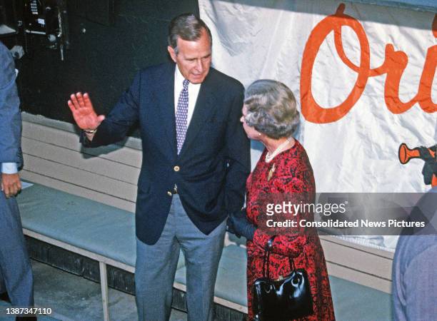 President George HW Bush speaks with British monarch Queen Elizabeth II in a dugout at Memorial Stadium, Baltimore, Maryland, May 15, 1991. During...