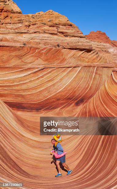 father and toddler daughter exploring the famous wave of coyote buttes north in the paria canyon-vermilion cliffs wilderness of the colorado plateau in southern utah and northern arizona usa - southern utah v utah stockfoto's en -beelden