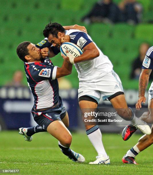 Isaia Toeava of the Blues is tackled by Mark Gerrard of the Rebels during the Super Rugby trial match between the Melbourne Rebels and the Auckland...