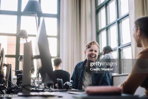 happy multiracial male and female computer programmers discussing at desk in office - transgender bildbanksfoton och bilder