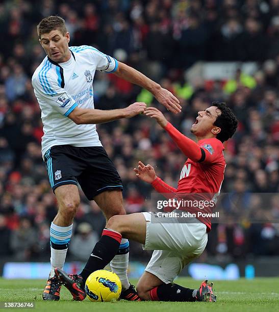 Steven Gerrard of Liverpool competes with Rafael Da Silva of Manchester United during the Barclays Premier League match between Manchester United and...