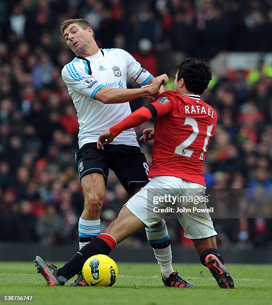 Steven Gerrard of Liverpool competes with Rafael Da Silva of Manchester United during the Barclays Premier League match between Manchester United and...