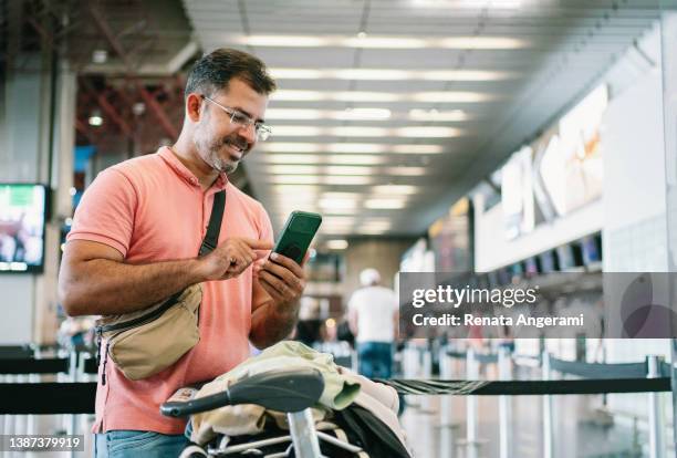 空港でチェックインを待っている成熟した男性 - 搭乗手続き ストックフォトと画像