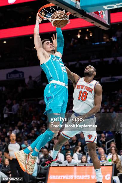 LaMelo Ball of the Charlotte Hornets dunks the ball while guarded by Alec Burks of the New York Knicks in the third quarter at Spectrum Center on...