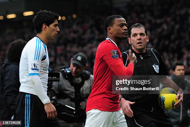 Patrice Evra of Manchester United celebrates victory as he walks off with Luis Suarez of Liverpool during the Barclays Premier League match between...