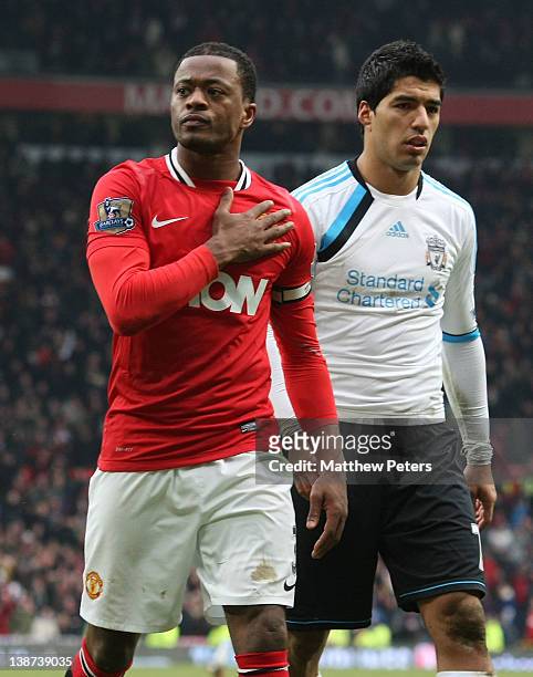 Patrice Evra of Manchester United celebrates while Luis Suarez of Liverpool walks off after the Barclays Premier League match between Manchester...