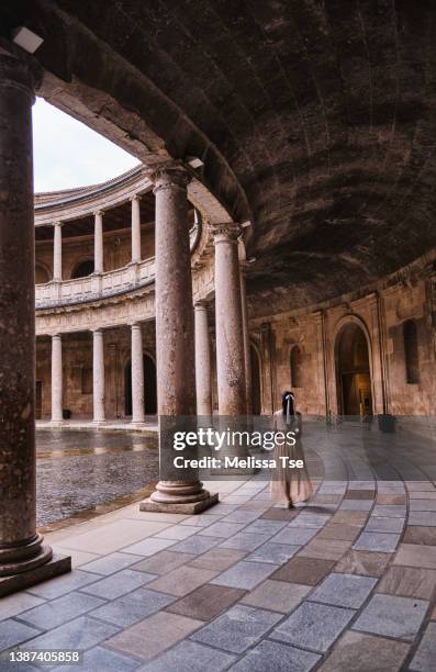 woman walking at the palace of charles v in the alhambra - alhambra foto e immagini stock