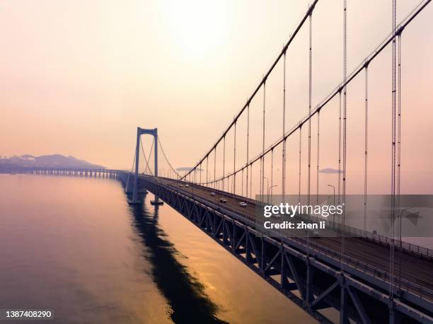 aerial view of cross-sea bridge at sunrise - hangbrug stockfoto's en -beelden