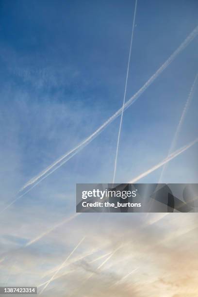 full frame shot of vapor trails and moody sky - sunset with jet contrails stock pictures, royalty-free photos & images