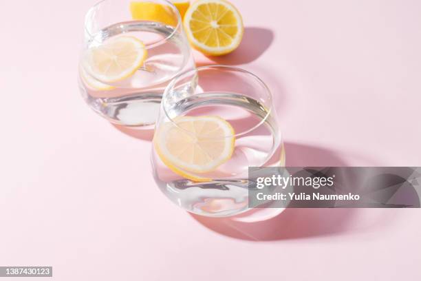 two glasses of water with lemon with hard light. - lemon juice stock pictures, royalty-free photos & images