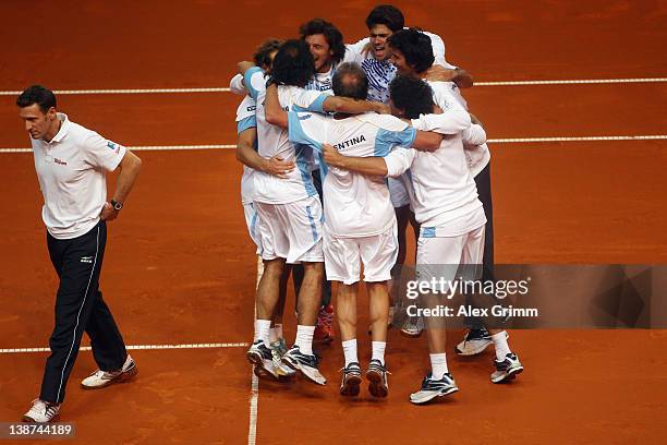 Germany's team captain Patrik Kuehnen walks past celebrating players of Argentina after David Nalbandian and Eduardo Schwank won their doubles match...