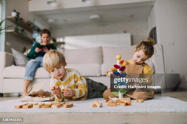 small brother and sister playing with marble run at home. - niño en la sala con juguetes fotografías e imágenes de stock