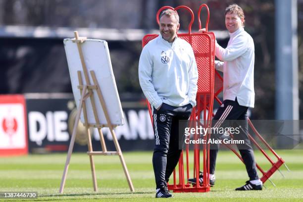 Head coach Hans-Dieter Flick and assistant coach Marcus Sorg smile as they prepare equipment for a training session of Germany at the Eintracht...