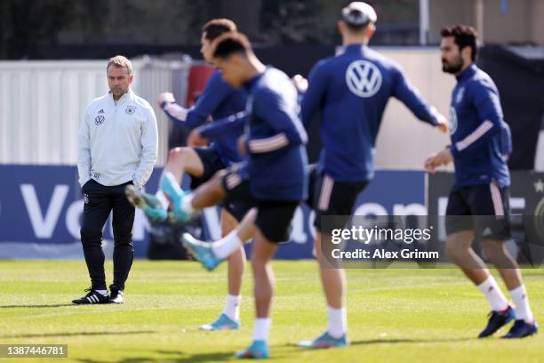 Head coach Hans-Dieter Flick watches players stretch during a training session of Germany at the Eintracht Frankfurt training ground on March 24,...